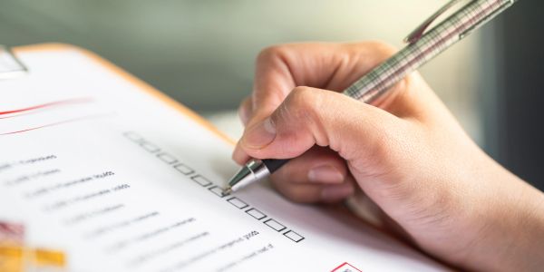 Hand checking boxes on a checklist.