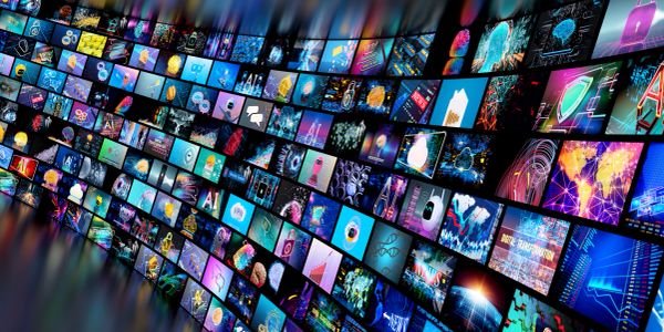 Curved wall of digital screens with tech visuals.