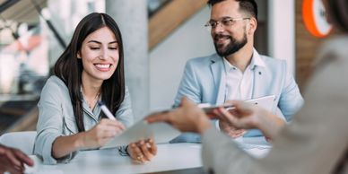 Businesswoman signing a document during a meeting with colleagues.