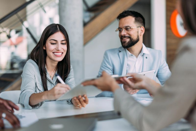 Shot of confident businesswoman filling in paperwork in an office. Business persons signing a document during a meeting in board room.