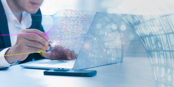 Businessman working on laptop with digital binary code and network graphics overlay.