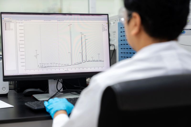 Researchers in lab coat at testing room are meticulously analyzing samples using GC-MS (Gas Chromatography-Mass Spectrometry) equipment. Compare the results with existing library standards, ensuring precision and accuracy in their scientific endeavors.