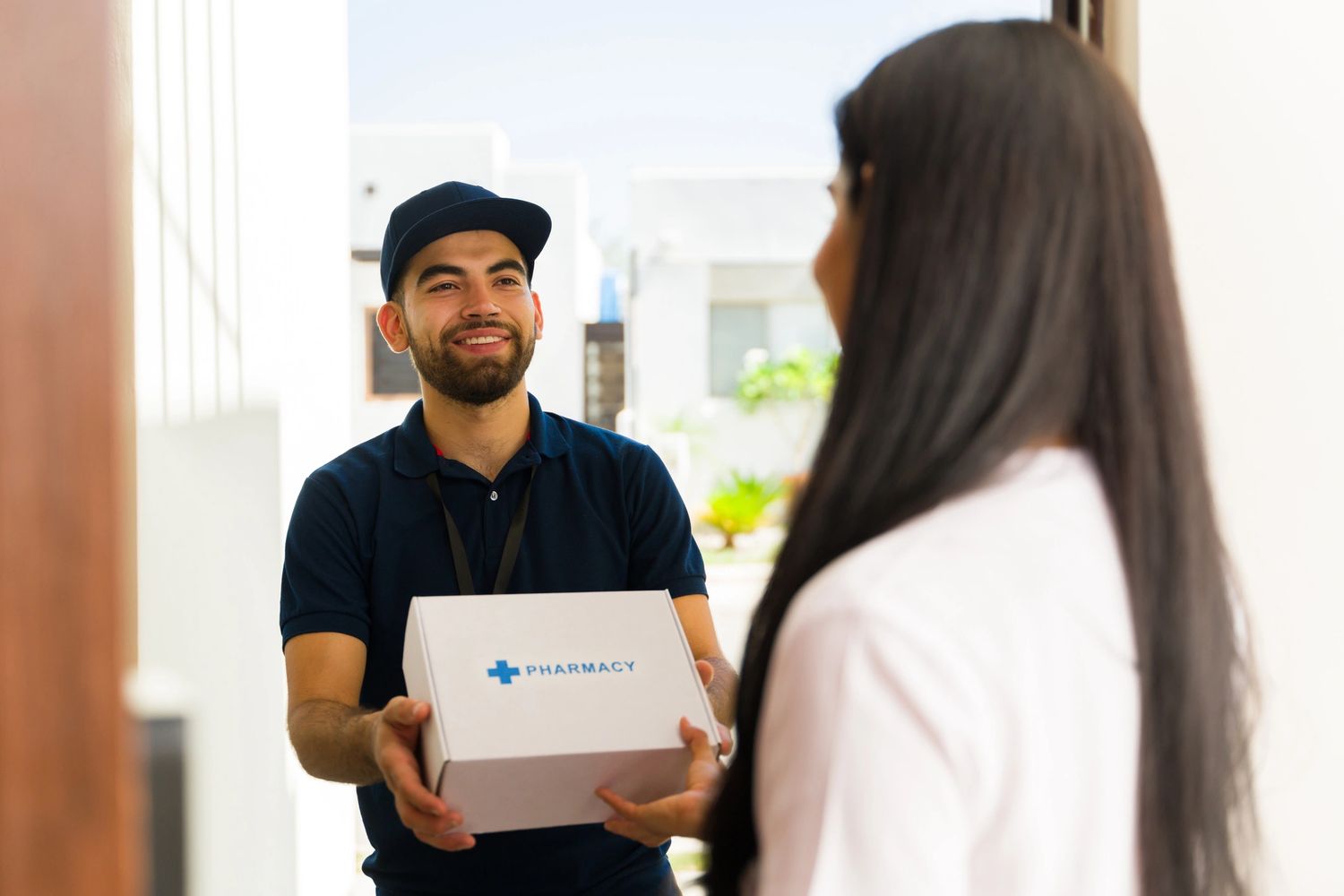 Delivery man handing over a pharmacy package to a woman.