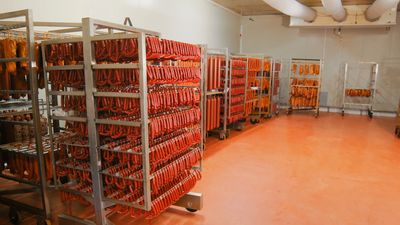 Racks of processed meat products in a food processing cool room