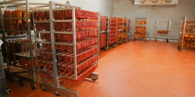 Racks of processed meat products in a food processing cool room
