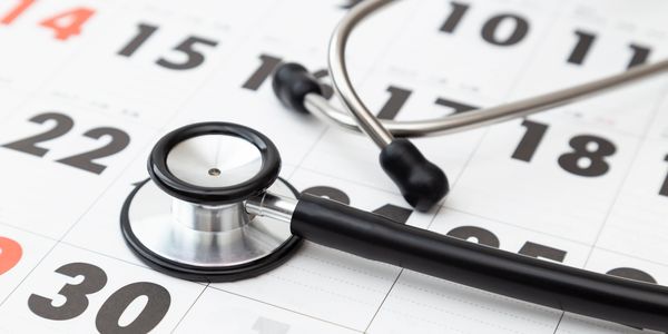 Stethoscope lying on a calendar, symbolizing a medical appointment.