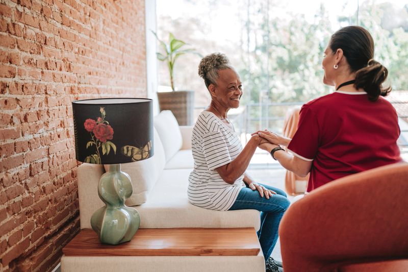 Home care healthcare professional talking to elderly patient
