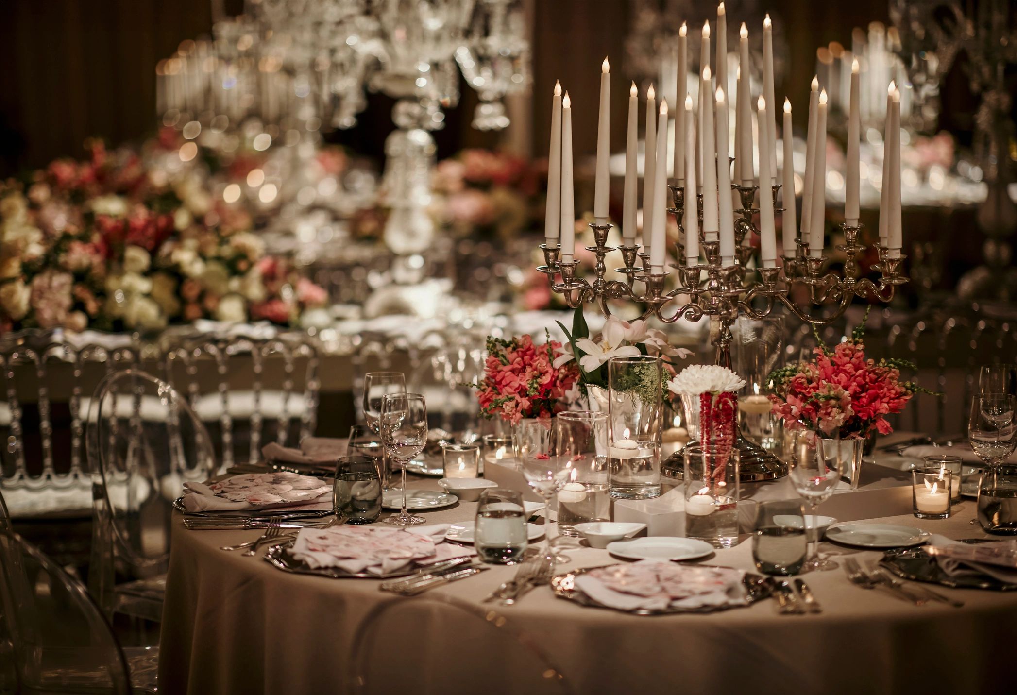 Elegant candlelit dinner table with floral arrangements.