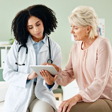 Doctor consulting with a patient using a tablet in a medical office.