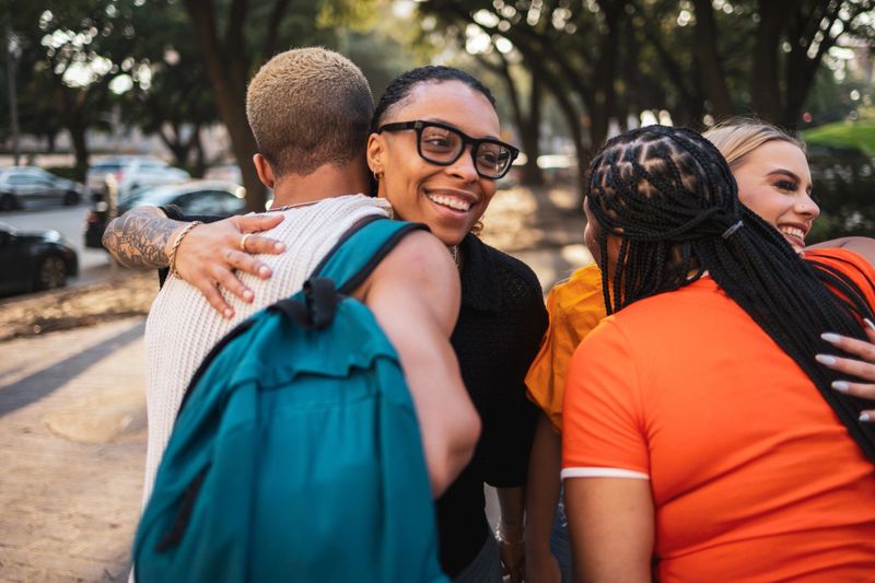 Happy friends hugging warmly outdoors in a park