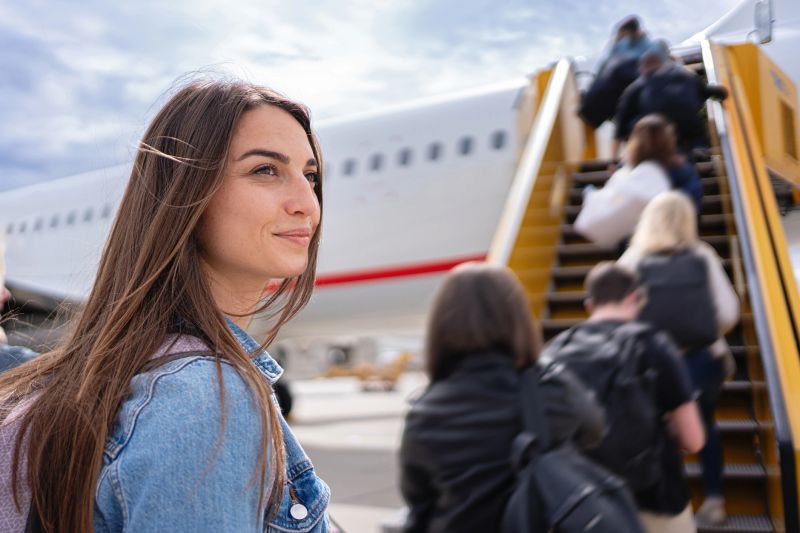 Close up of a young woman walking to the airplane to board her flight