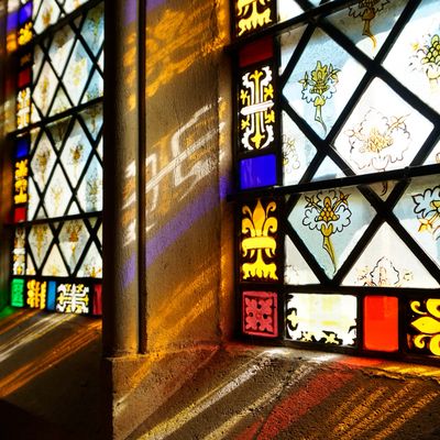 Light shining through colorful stained glass windows casting vibrant patterns.