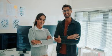 Two colleagues smiling confidently in an office.