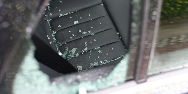 Broken car window with shattered glass on the seat