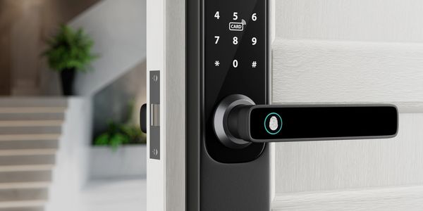 Modern black digital door lock with keypad and fingerprint scanner on a white door.