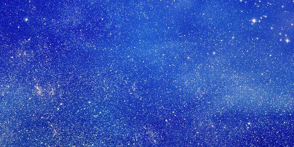 A vibrant blue texture with sparkling gold glitter scattered throughout.