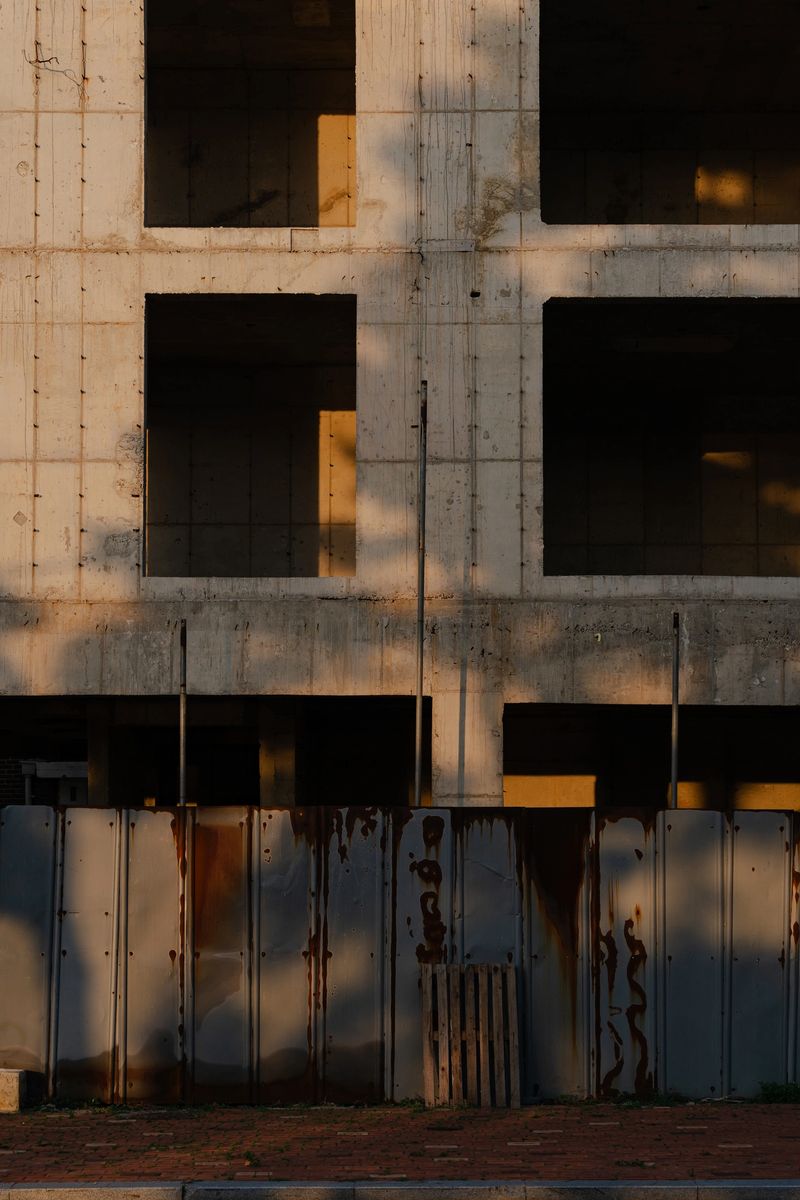 Abandoned Building Facade with Rusty Fence