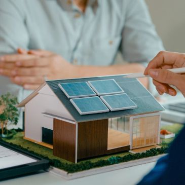 Model house with solar panels being discussed.