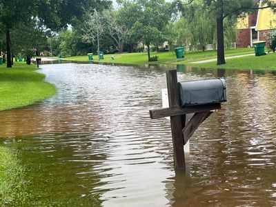 Mailboxes partially submerged in floodwater on a street.