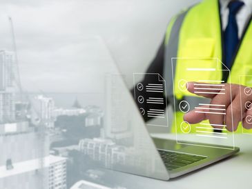 Engineer using virtual checklists on a laptop in a construction environment.