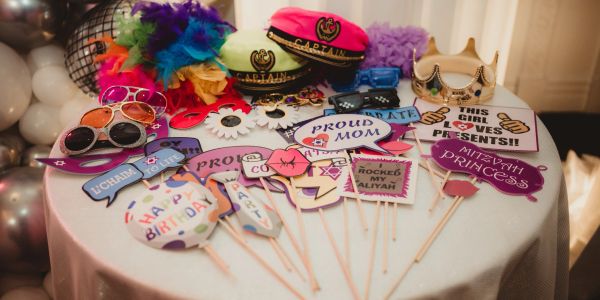 Colorful party props and hats arranged on a round table.