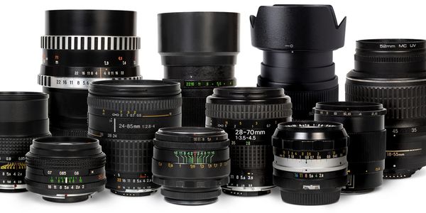 A collection of various camera lenses arranged on a white background.