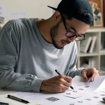 A man designing logos at a desk, focused and creative.