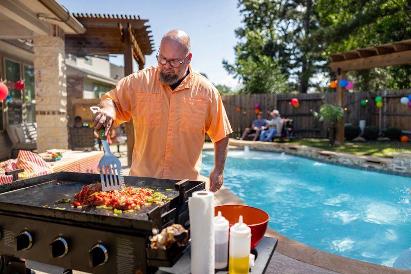 Latin American man making Mexican food while having a barbecue at home with his family - lifestyle concepts