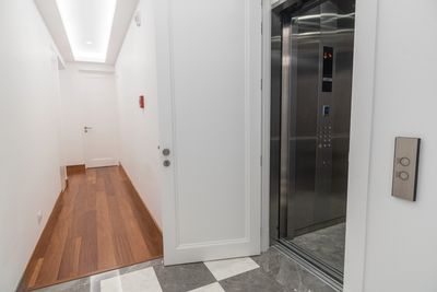 Modern hallway with wooden floor and open elevator.
