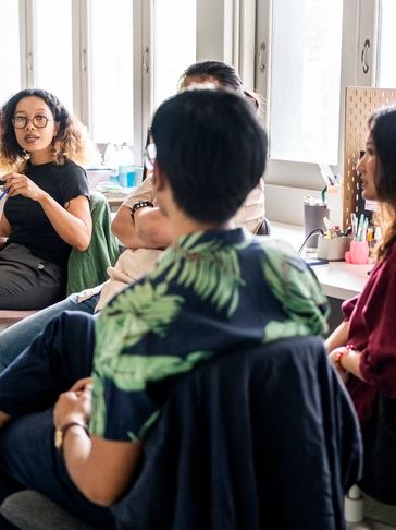 A group of people engaged in a discussion in a bright room.