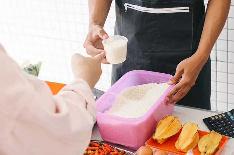Hand Of Customer Asking Seller To Measure Rice Grain To Be Purchased