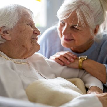 Elderly patient with caregivel, representing mobile notary services for healthcare documents.