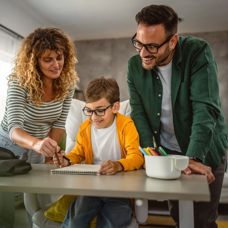 Happy family of three draw together on paper at home