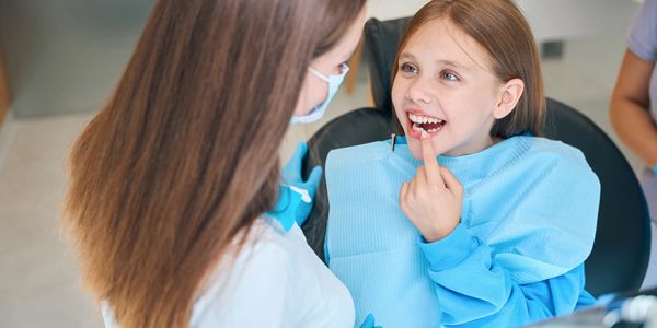 Pediatric dentist examining child’s teeth at Myrtle Dental Clinic