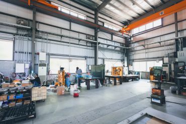 Spacious industrial workshop with machinery and workbenches.