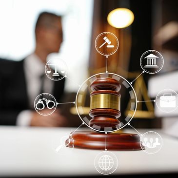 Wooden gavel with legal icons and a blurred lawyer in background.