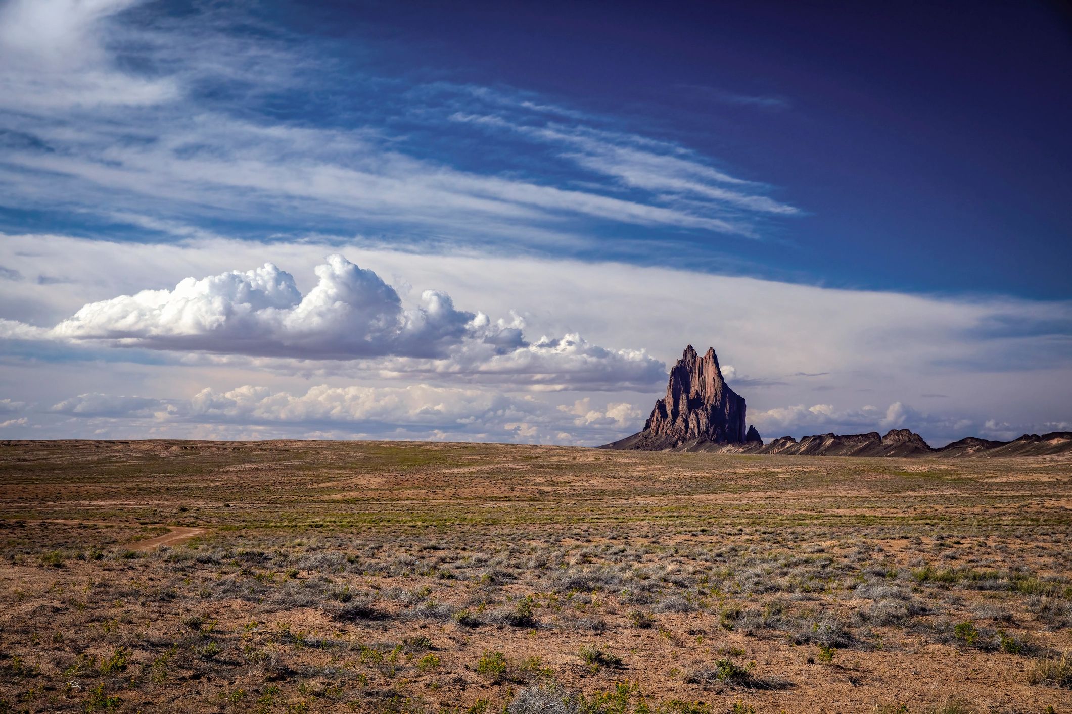 Shiprock rises in a vast desert under a bright blue sky in northwestern New Mexico.