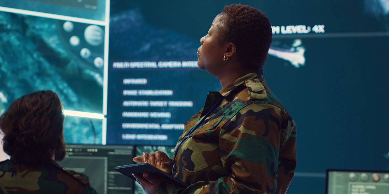 Military personnel analyzing data on digital screens in a command center. Leadership and precision.