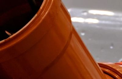 Close-up of a sewer pipe with an inspection camera cable.
