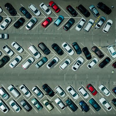 Aerial view of a crowded parking lot with various cars.