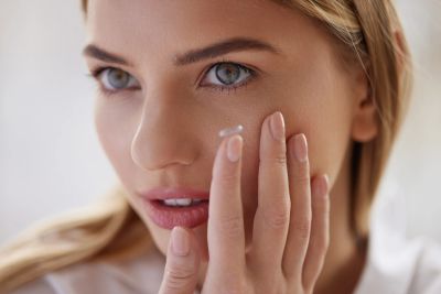Woman applying cream to her face.