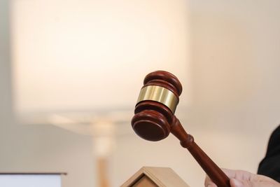 Gavel striking a small wooden house symbolizing a real estate auction or legal decision.