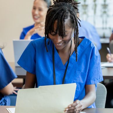 Nurse reviewing a document in a classroom.