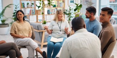 A diverse group in a supportive group therapy session in a cozy room.
