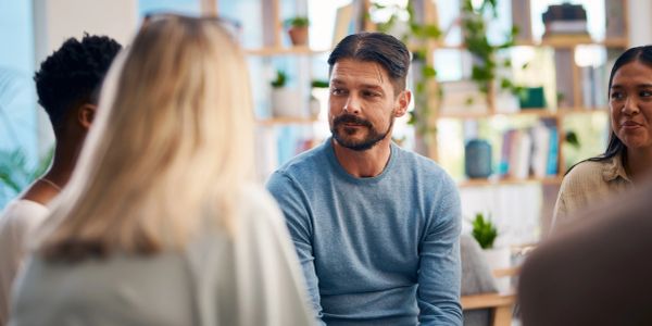 Man attentively listening in a group discussion.