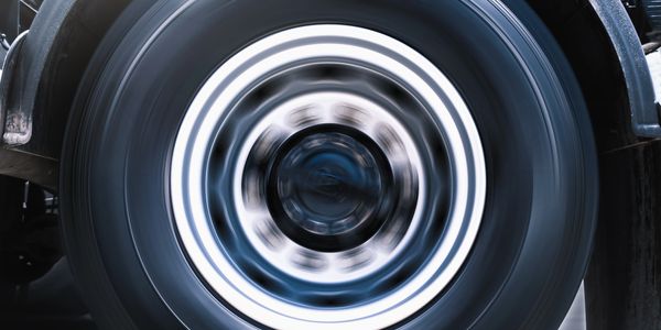 Close-up of a car tire spinning rapidly, creating a motion blur effect.