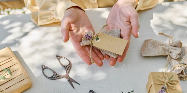 Hands holding a wrapped gift with a blank tag.