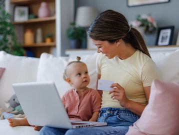 Mom registering to consign kids’ clothes on a laptop with Cola Kids Consignment
