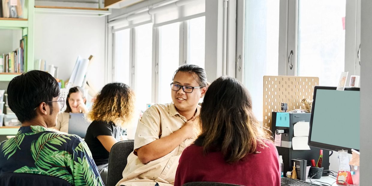 Group of coworkers having a discussion in an office.