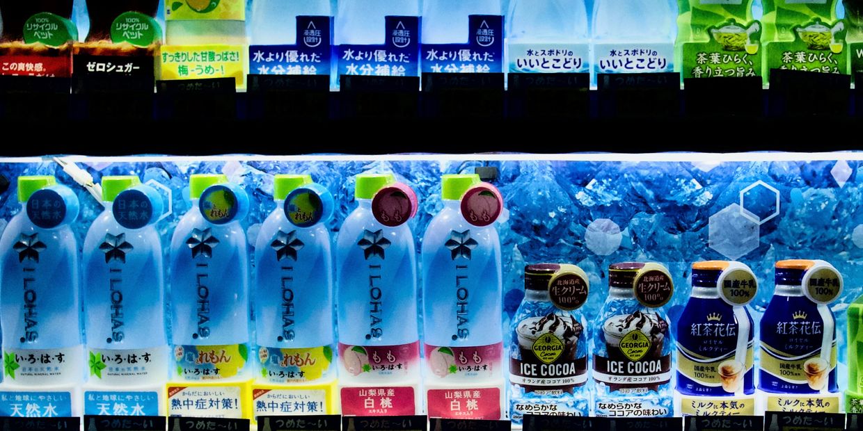 Japanese vending machine stocked with various colorful beverages.